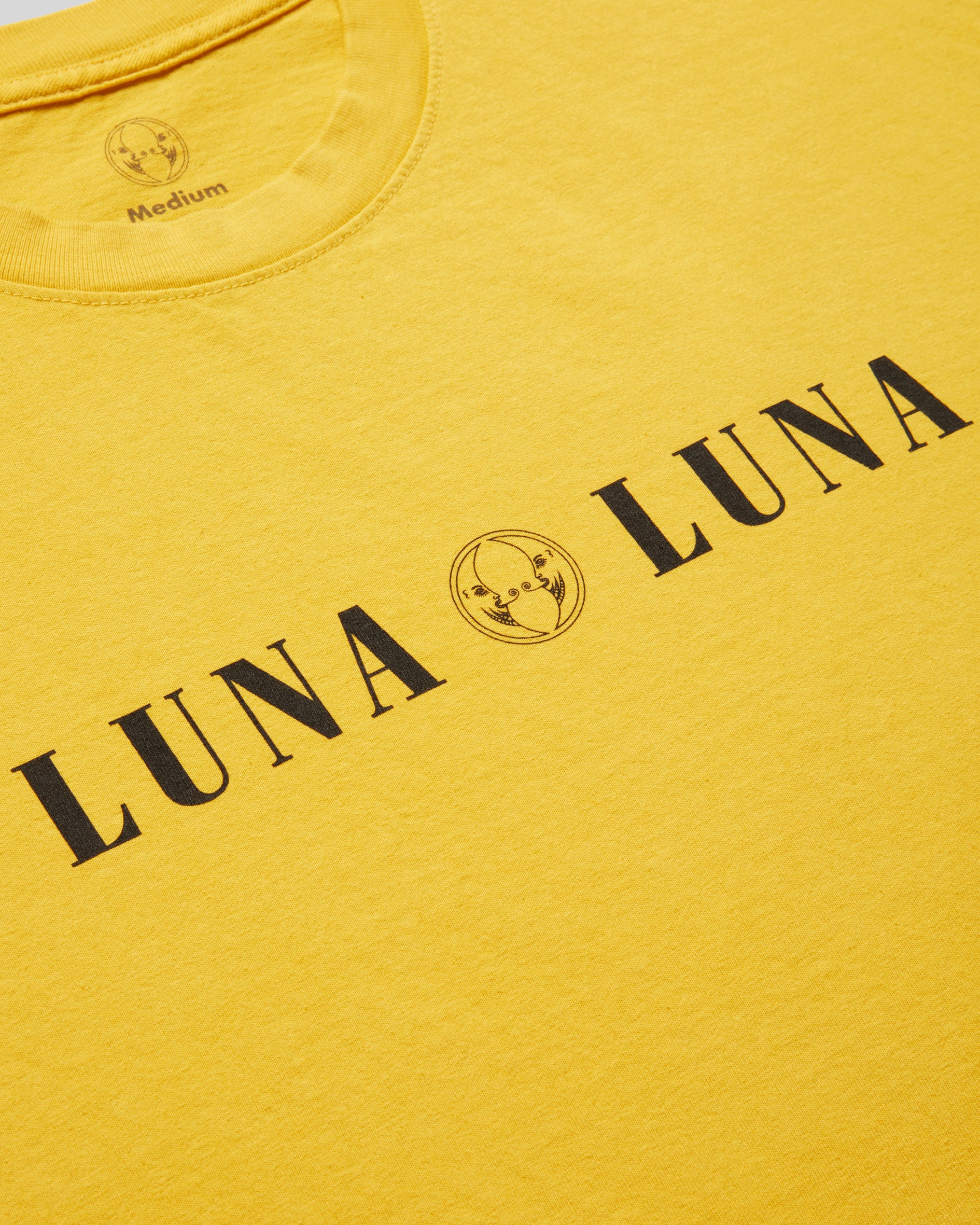 1987 Luna Luna T-Shirt in Yellow. Close up photograph ofyellow t-shirt with black text at chest that reads "LUNA LUNA"