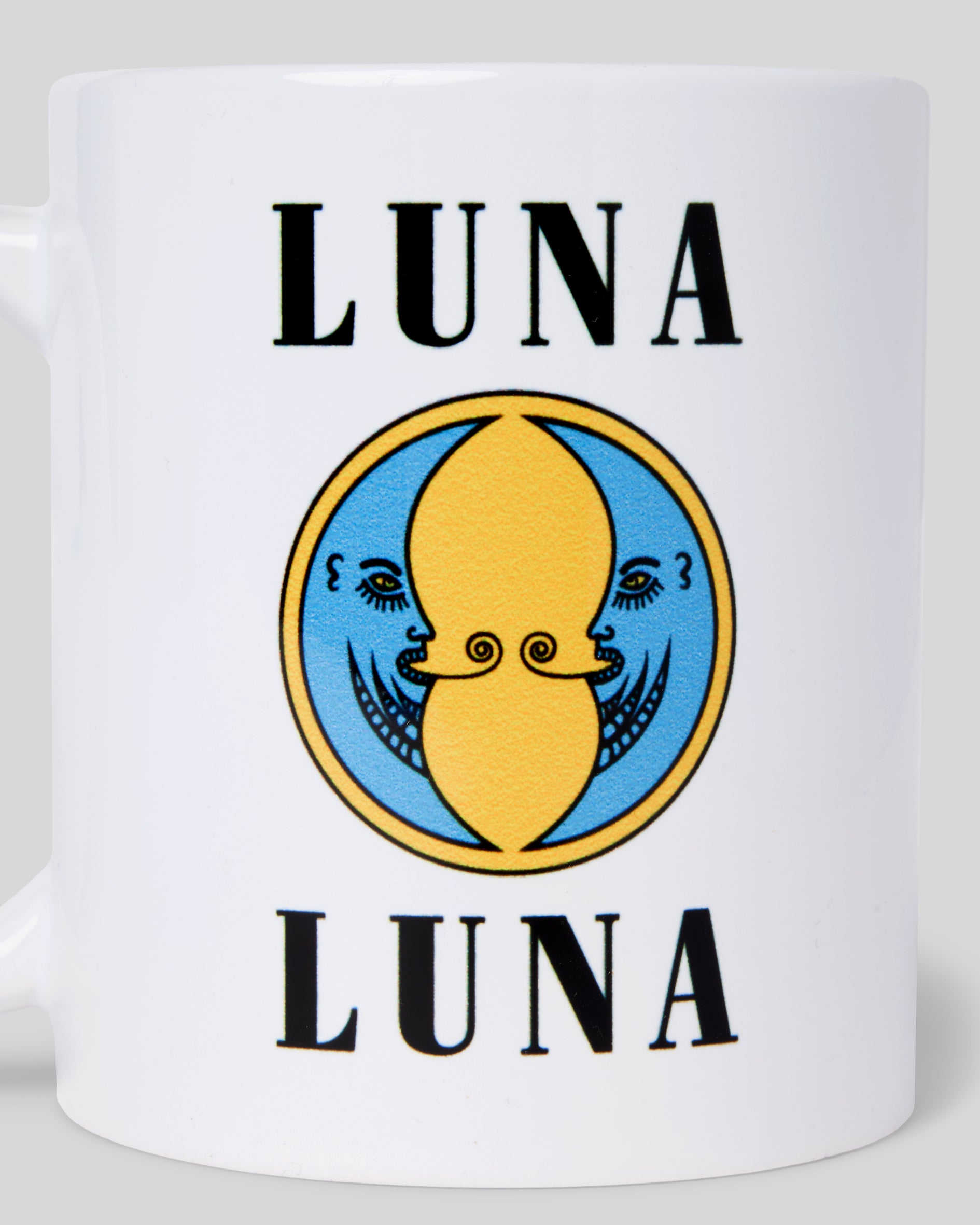 1987 Moon Diner Mug. Close up photograph of white coffee mug with black "LUNA LUNA" logo and blue and yellow moon logo.